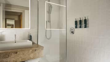 A modern bathroom with a rectangular sink, a glass-enclosed shower, and a mirror.