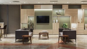 Un interior moderno con una zona de estar, un televisor de pantalla plana y plantas decorativas.