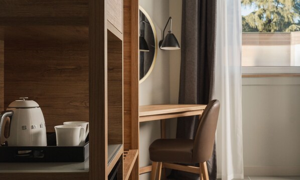 Una stanza moderna con una scrivania in legno, una sedia, una macchina per il caffè e un vassoio con tazze.