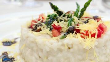 A plate of rice with vegetables and cheese.