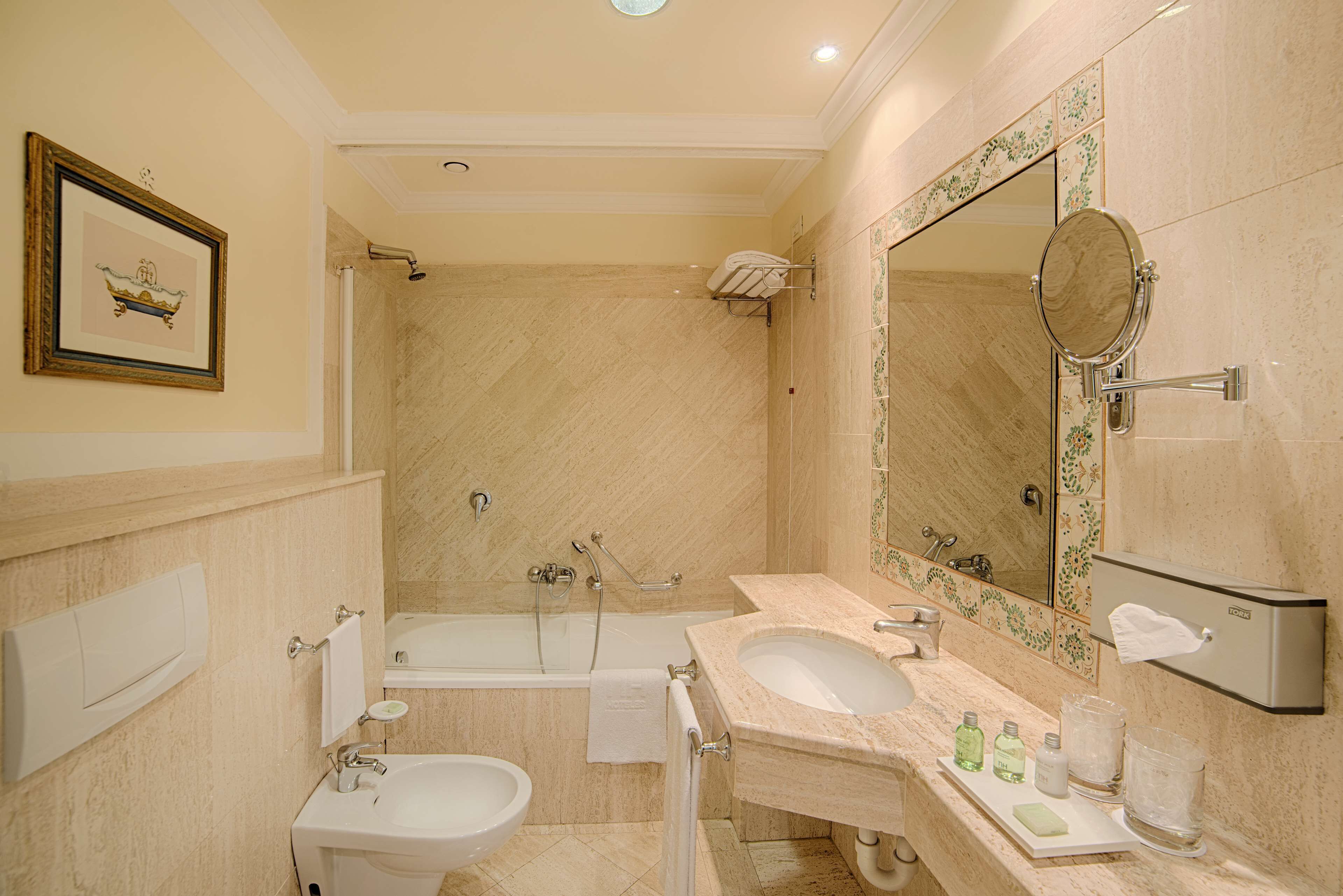 Un baño con bañera, dos lavamanos, un espejo grande y un cuadro en la pared.