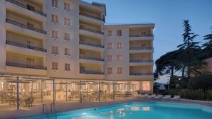 Ein Hotel mit Schwimmbad, Außenbereich und mehreren Balkonen.