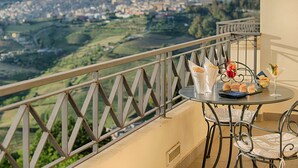 Ein Balkon mit Essplatz, mit Blick auf eine reizvolle Landschaft.