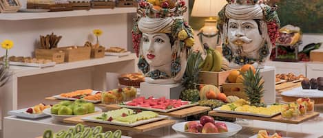 Una mesa de buffet con diversas frutas y pasteles.