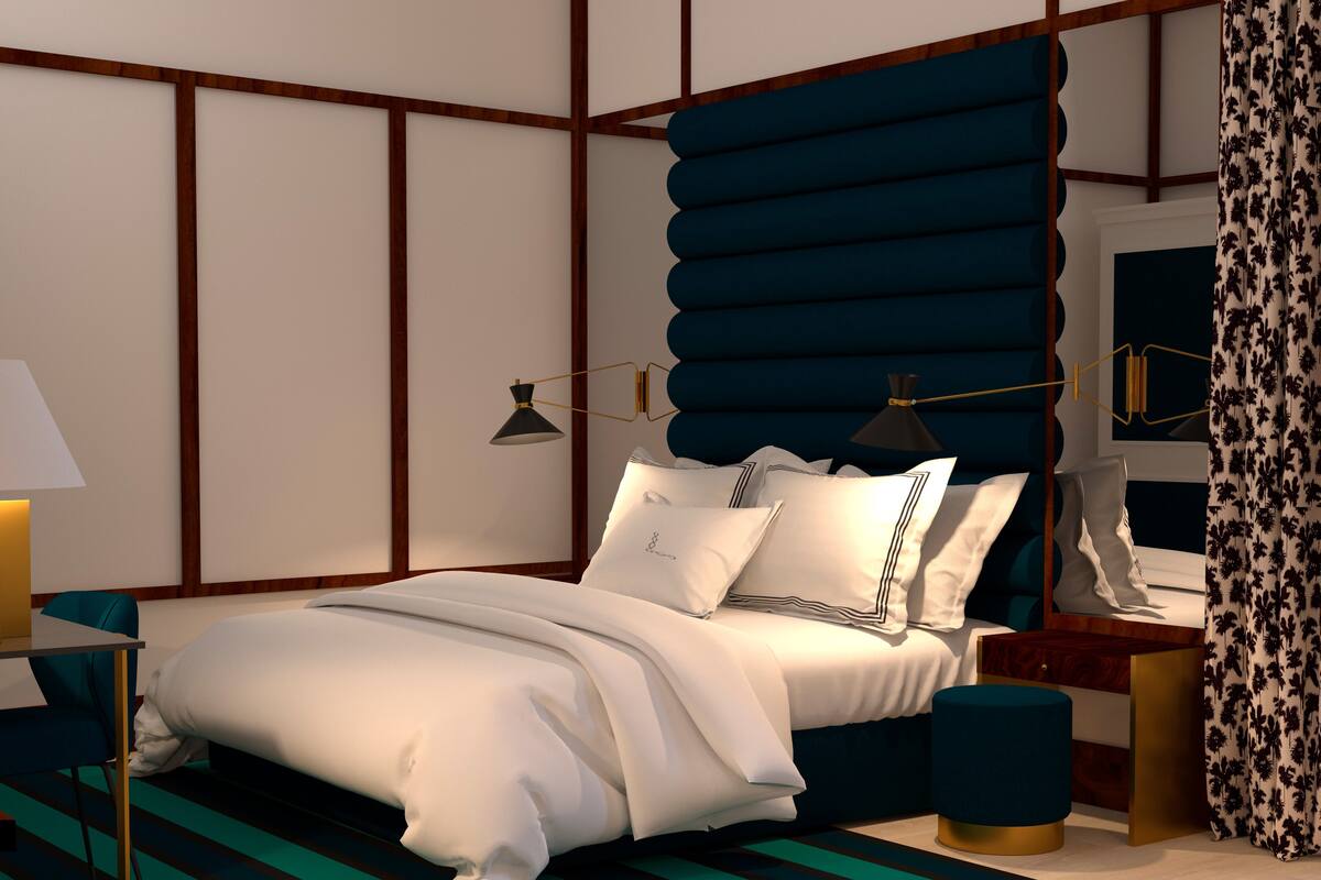 Une chambre moderne avec un grand lit, une table de chevet, une lampe et un rideau à motifs.