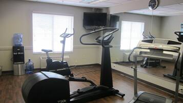 A gym with cardio equipment including a treadmill, elliptical, and stationary bike.