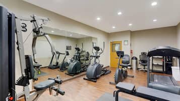 A gym with various exercise equipment, including treadmills, elliptical machines, and weight machines.