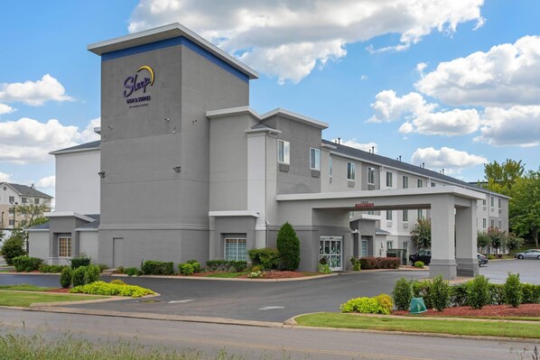 A Sleep Inn & Suites hotel with a modern design, featuring a prominent logo on the building's facade.