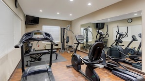A gym with treadmills, elliptical machines, and weight equipment.