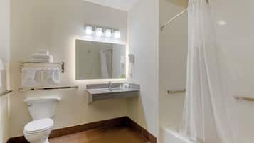 Un baño con inodoro, lavamanos y cortina de ducha.