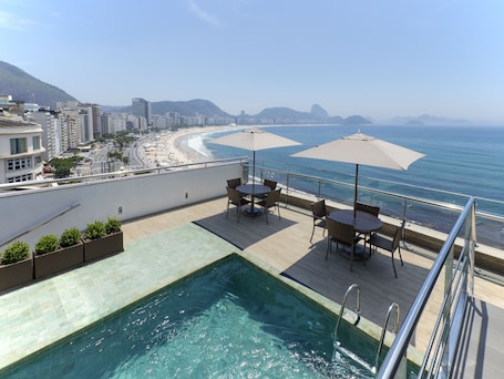On the beach, white sand, beach towels. Orla Copacabana Hotel