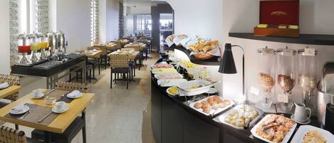 Een buffetopstelling met diverse etenswaren en een koffiehoek.