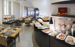 A buffet setup with various food items and a coffee station.