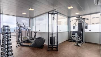 A gym with various exercise equipment, including a treadmill, elliptical, and weight machines.