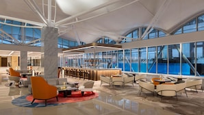 A spacious lobby with modern seating, a bar area, and large windows offering views of the sea. - Wyndham Singapore Hotel (Singapore)