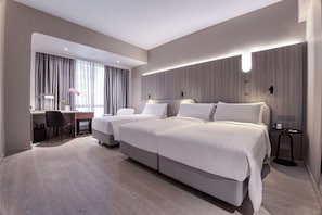 Deluxe Triple Room | Minibar, in-room safe, desk, blackout drapes