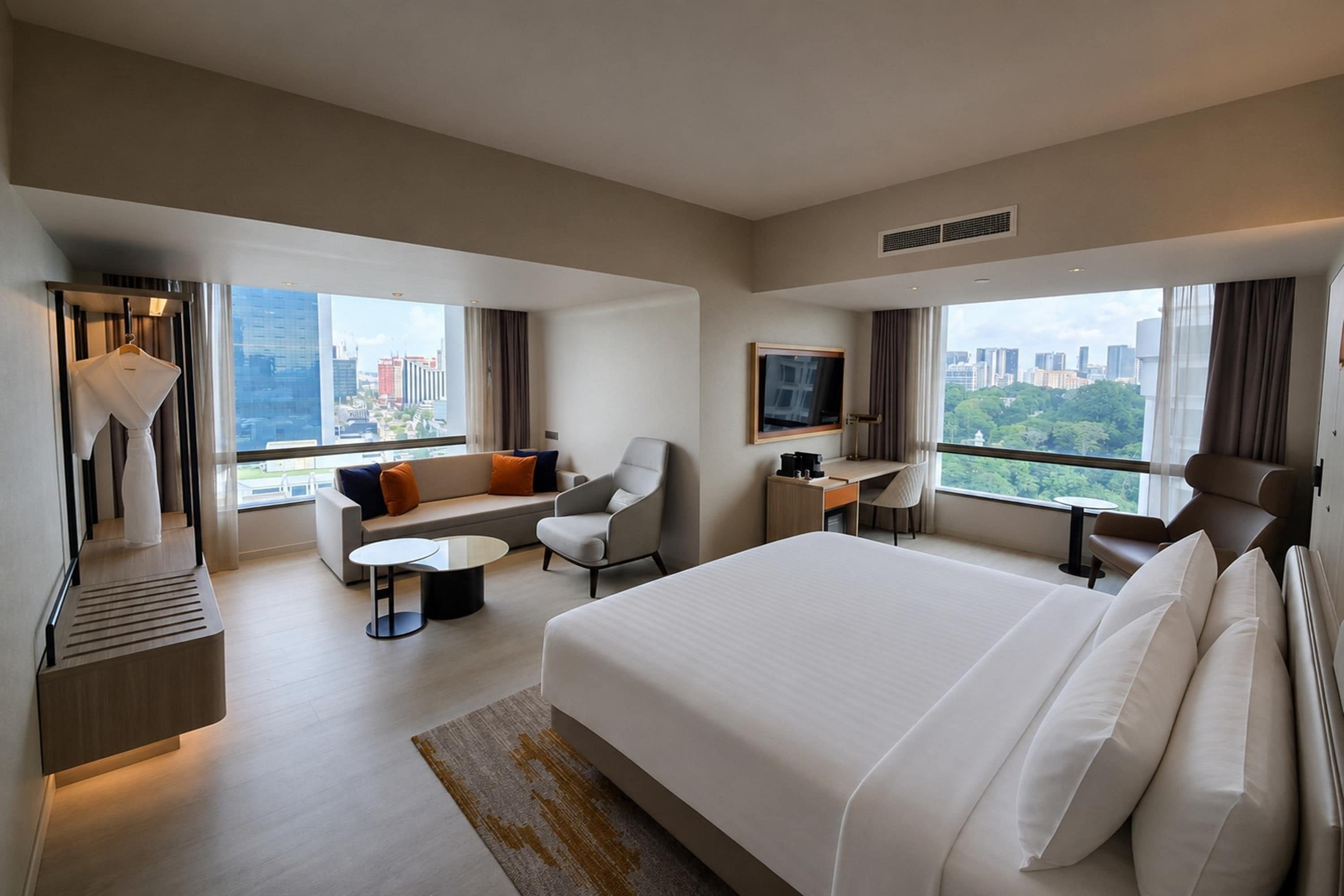Een moderne hotelkamer met een groot bed, een bank, een bureau en een televisie.
