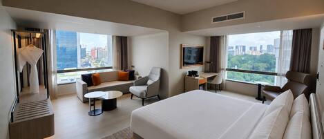 Een moderne hotelkamer met een groot bed, een bank, een bureau en een televisie.