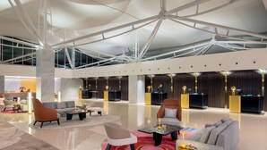 A spacious lobby with modern furniture, a high ceiling with structural beams, and a reception desk. - Wyndham Singapore Hotel (Singapore)