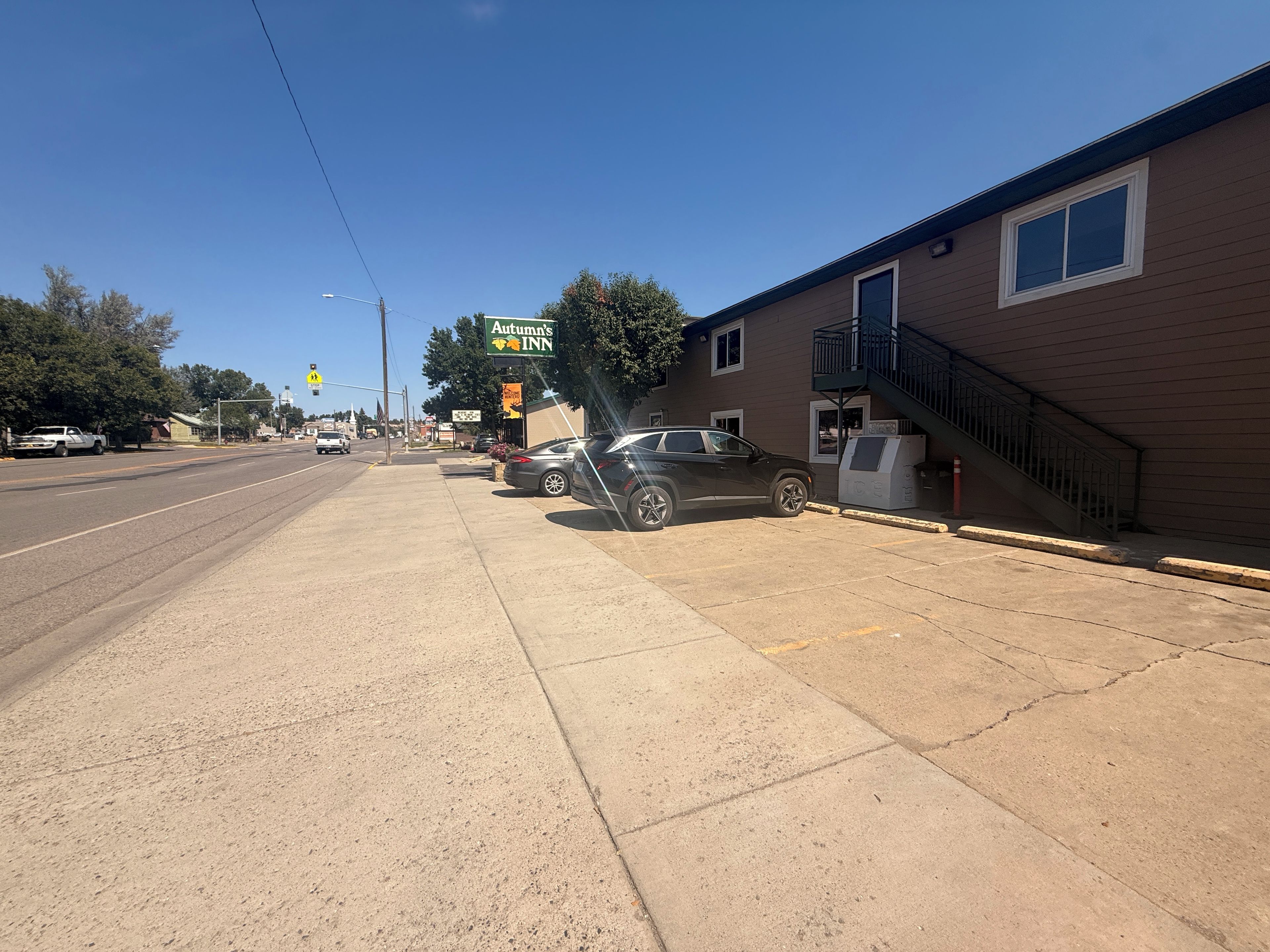 A street view with a building labeled 'Autumn's Inn' and a parked car.