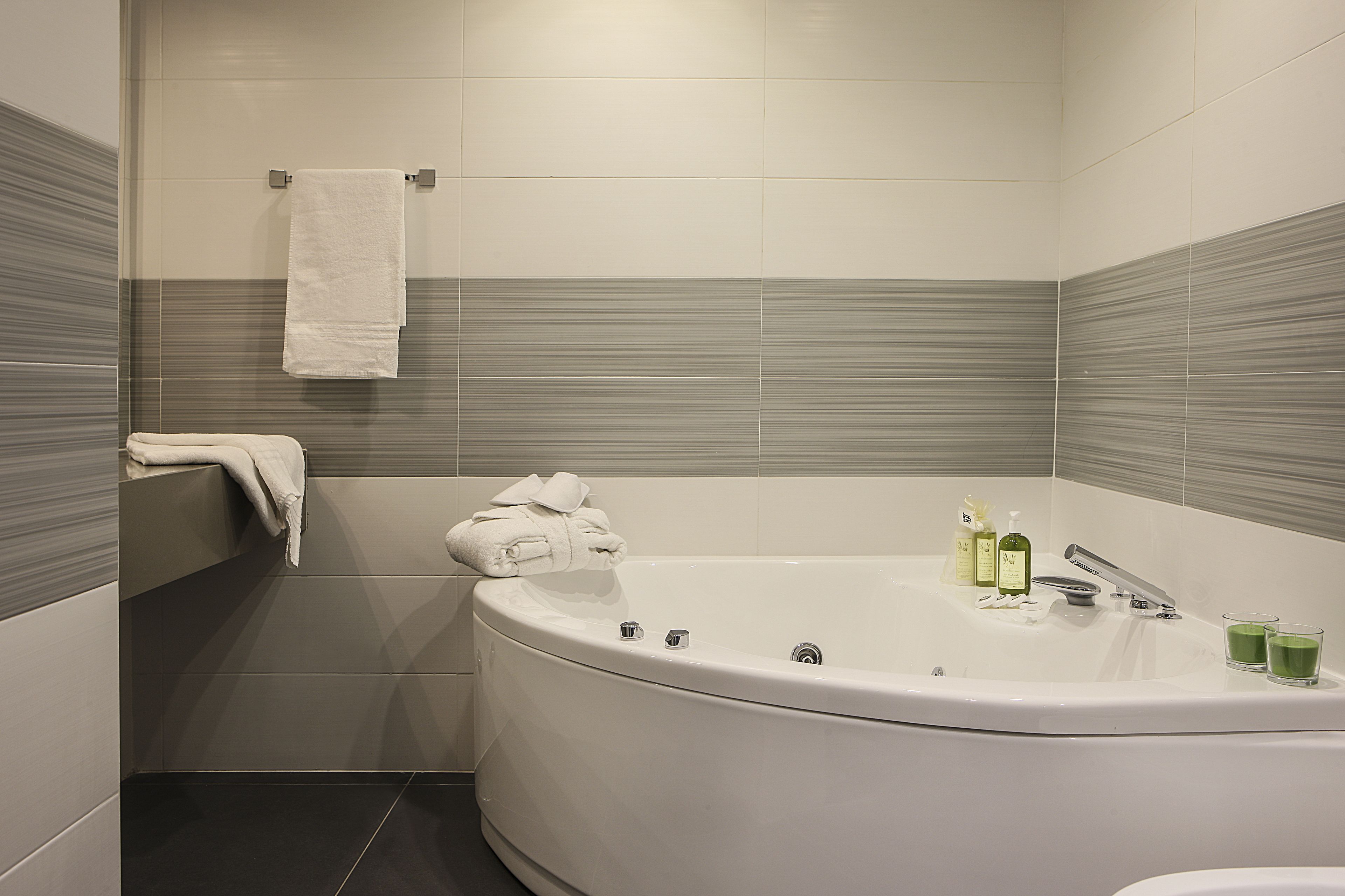 A modern bathroom with a freestanding bathtub, a towel rack, and two bottles of shampoo.