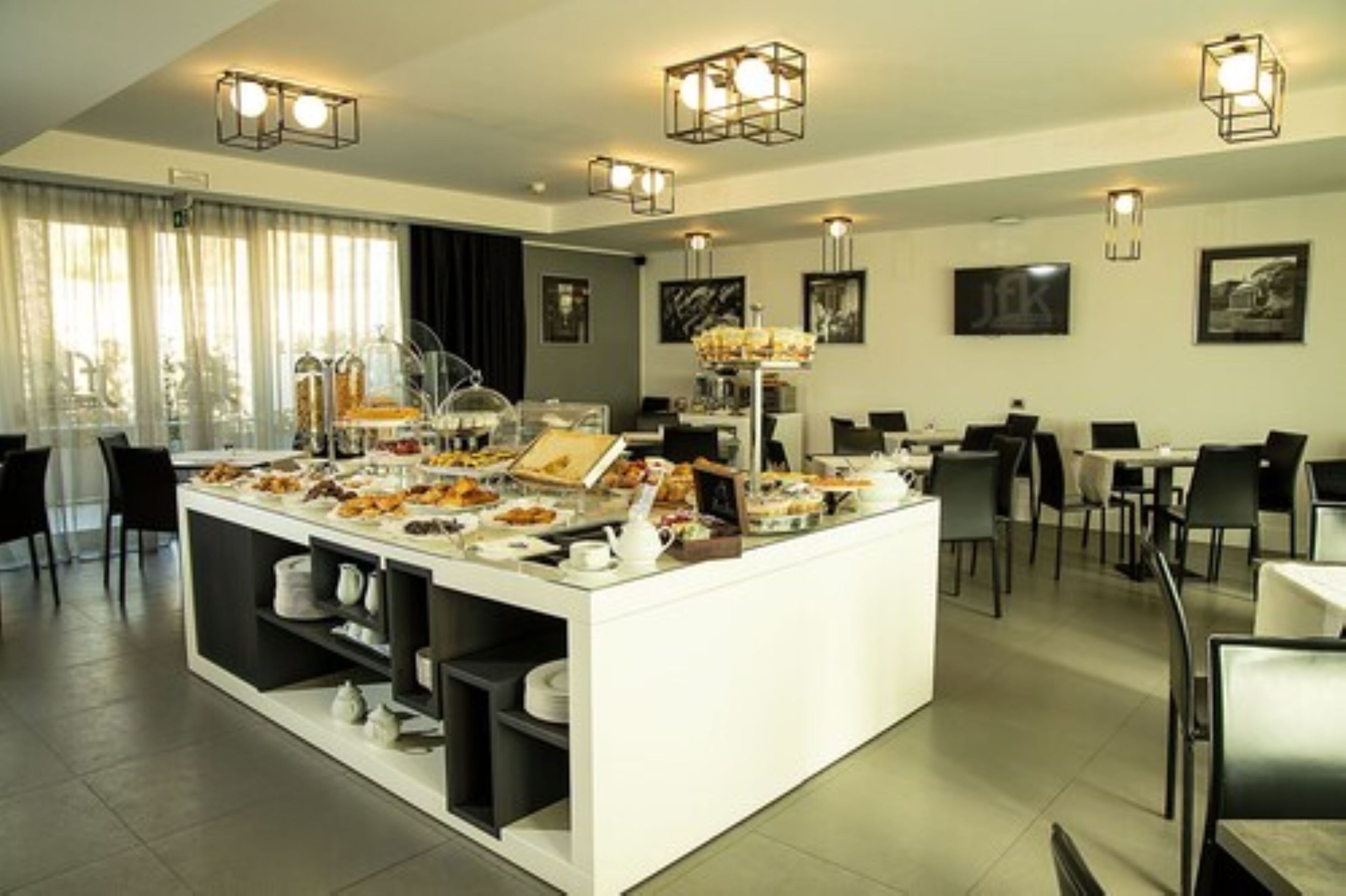 Un comedor moderno con un sistema de buffet, diversas opciones de asientos y lámparas de diseño contemporáneo.