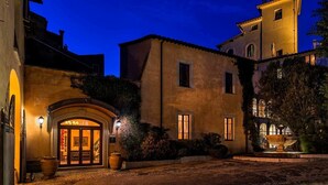 A historic building with a central entrance, large windows, and a courtyard with a fountain. - Relais Falisco (Civita Castellana)