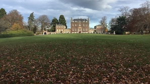 A large, historic building with a symmetrical facade, surrounded by a well-maintained lawn and mature trees. - Culloden House Hotel (Inverness)