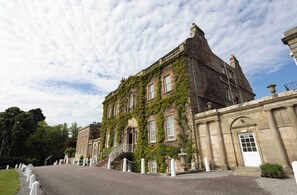 A historic building with ivy-covered walls, a grand entrance, and a paved driveway. - Culloden House Hotel (Inverness)