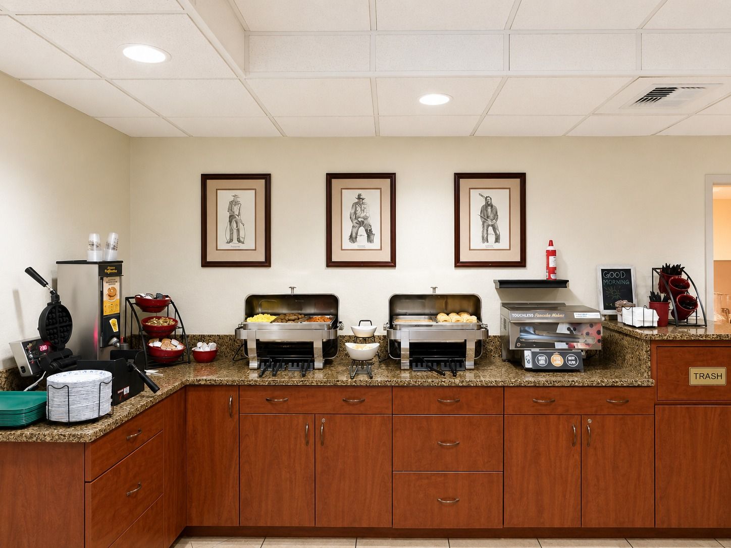 A breakfast bar with waffle maker, buffet, and touchless fryer.
