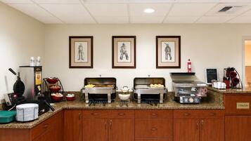 A breakfast bar with waffle maker, buffet, and touchless fryer.