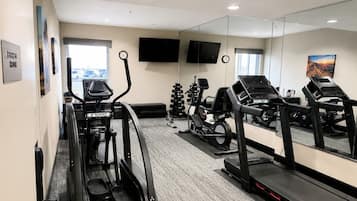 Ein Fitnessraum mit Laufbändern, einem Ergometer und einer Gewichtbank.