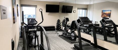 A gym with treadmills, a stationary bike, and a weight bench.