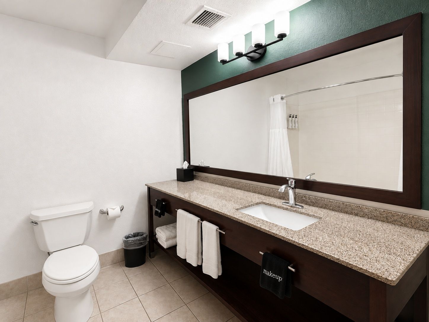 A modern bathroom with a toilet, sink, and mirror.