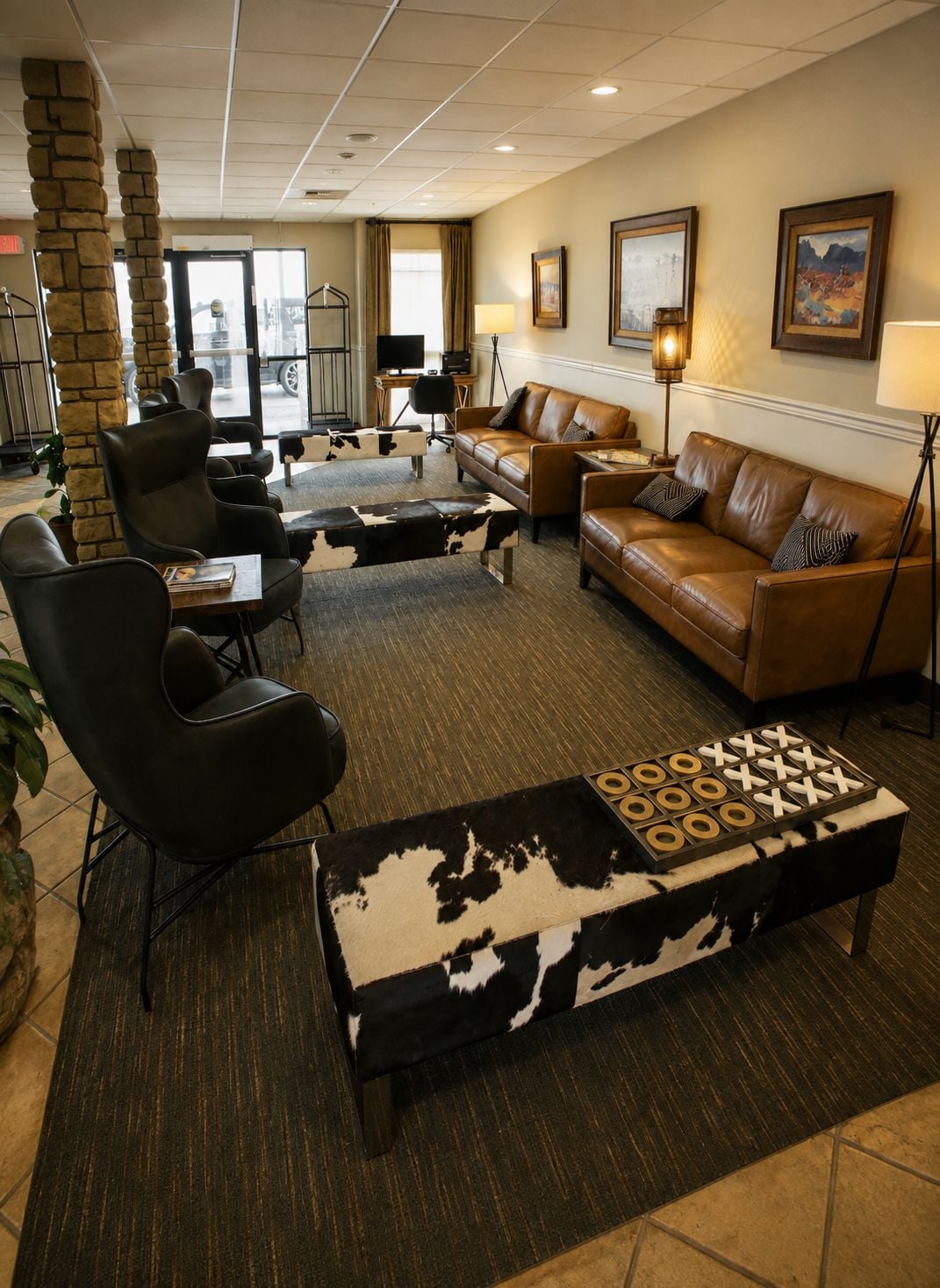 A hotel lobby with leather sofas, a coffee table, and a stone pillar.
