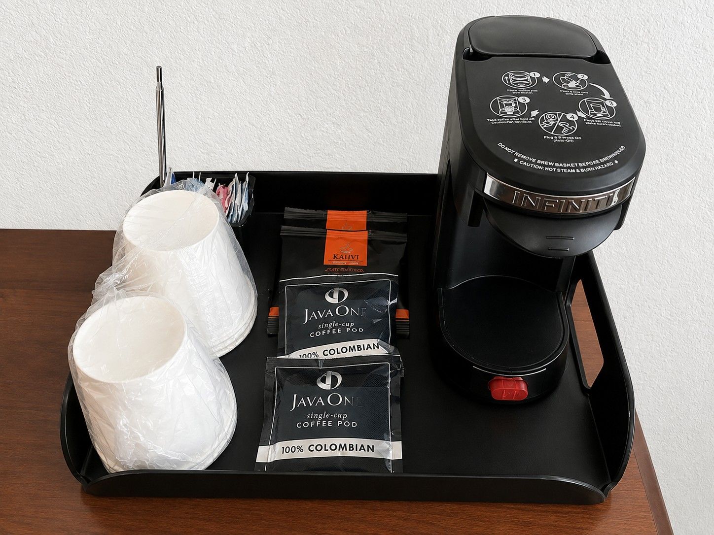 Una bandeja con una cafetera, dos tazas y dos cápsulas de café JavaOne.