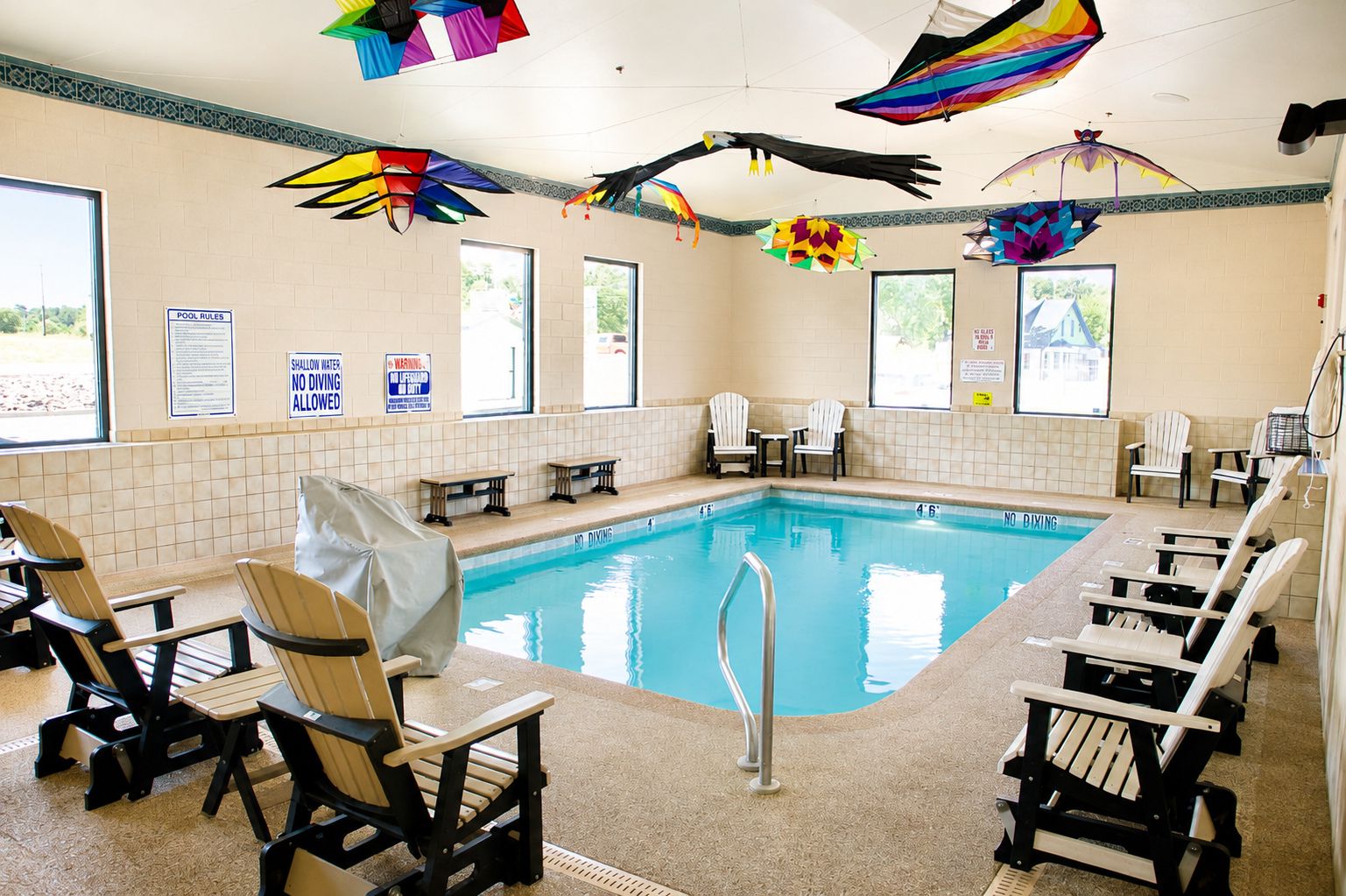 Une piscine intérieure dotée de chaises longues et d’un espace aménagé au bord du bassin.