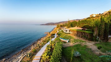 Playa privada, playa de arena negra, camastros y sombrillas
