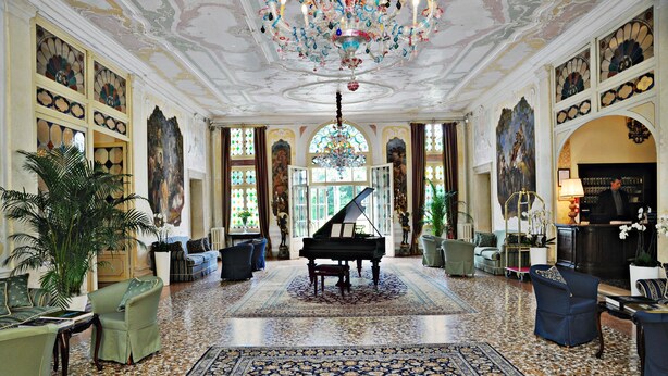 A grand room with a grand piano, ornate chandeliers, and a large, patterned carpet. - Hotel Villa Condulmer (Mogliano Veneto)