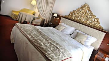 Una habitación de hotel con una cama grande, una mesita de noche, una lámpara y una silla.