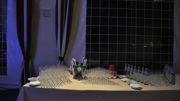 A table set with numerous wine glasses and bottles, likely for a formal event.
