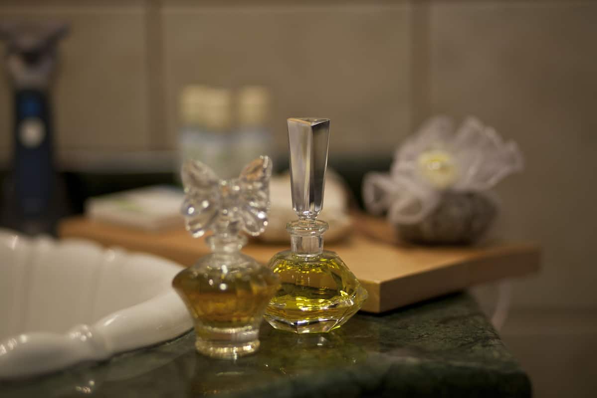 Dos botellas de perfume sobre una encimera de mármol.