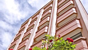 Un edificio alto con un diseño arquitectónico moderno, caracterizado por líneas verticales y ventanas rectangulares.