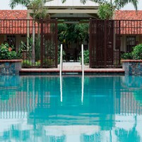 Una piscina al aire libre, sombrillas, sillones reclinables de piscina