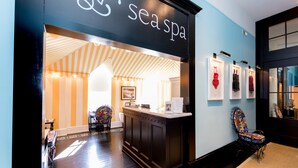 A spa entrance with a reception desk, a patterned ceiling, and framed artwork on the wall.