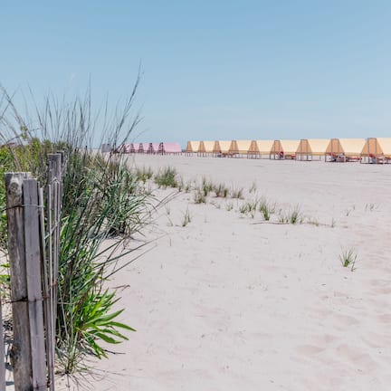 On the beach, white sand, beach cabanas, sun loungers