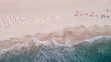 On the beach, white sand, beach cabanas, sun loungers