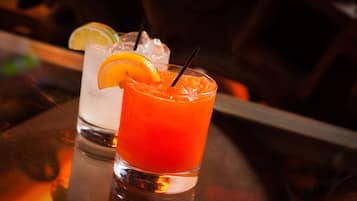Two glasses of cocktails on a bar counter.