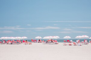 En la playa, arena blanca, camas de playa, sillas reclinables de playa