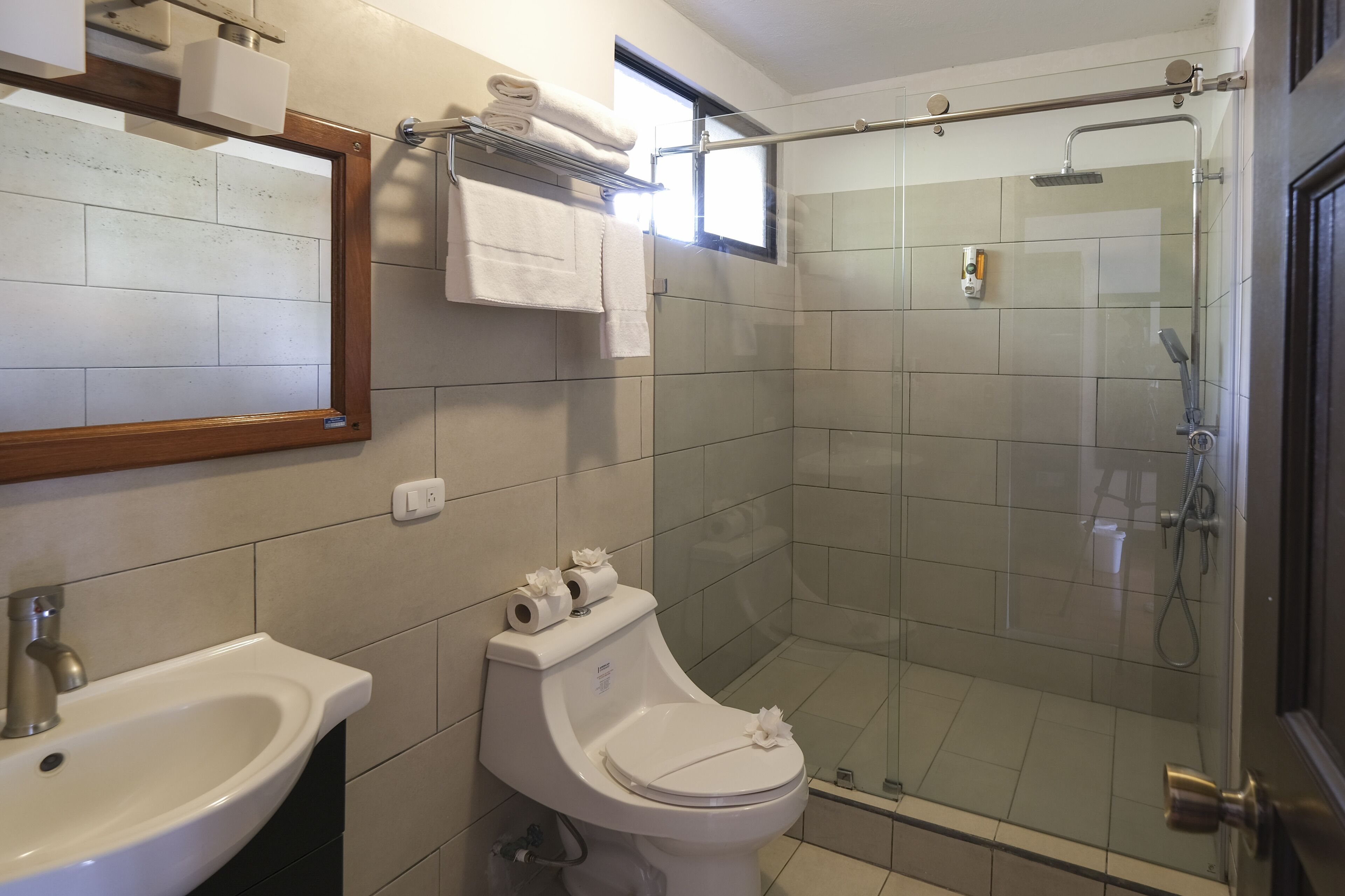 A modern bathroom with a sink, toilet, and glass-enclosed shower.
